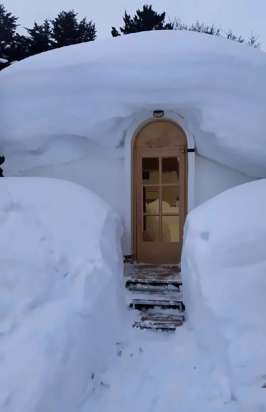 Entry door of an EPS dome cabin fully clear and operable between snow banks taller than the door
