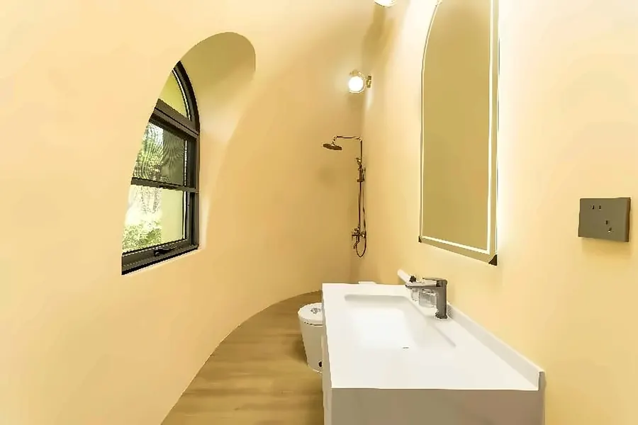 Dome bathroom fit-out with arch window, shower, and vanity