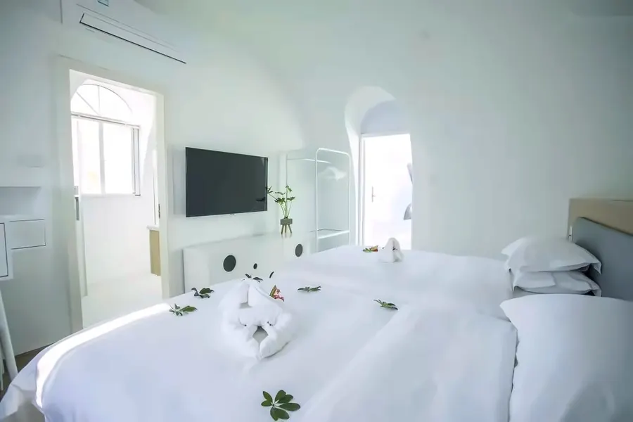 White twin guest room with en-suite bathroom and wardrobe rack